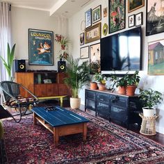 a living room filled with furniture and lots of pictures on the wall above it's flat screen tv