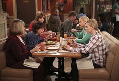 four women sitting at a table with plates of food and drinks in front of them