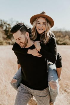 a man carrying a woman on his back in a field