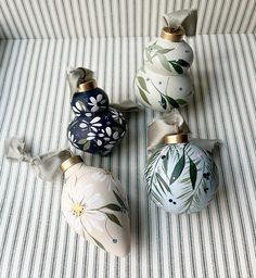 four ornaments are sitting on a striped surface