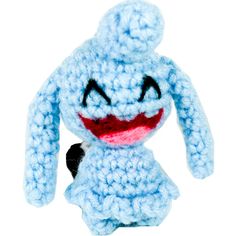 a crocheted blue stuffed animal with a red nose and black tail, sitting on a white surface