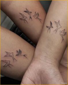 three small tattoos on the arms of two women, one with birds and one without