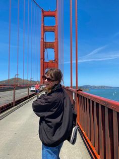 a woman standing on the side of a bridge