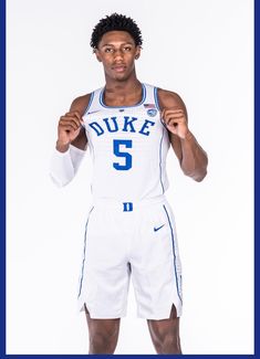 a basketball player poses for a photo in his white uniform with the number 5 on it