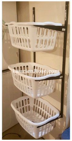 three white laundry baskets sitting on top of a metal rack