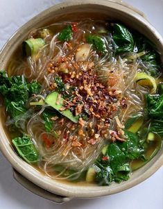 a bowl filled with soup and vegetables on top of a table