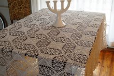 a crocheted table cloth with a menorah on it in front of a window