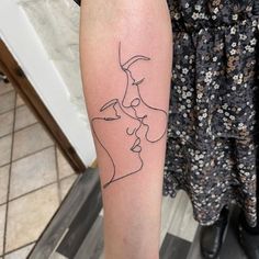 a woman's arm with a line drawing of a man and woman on it