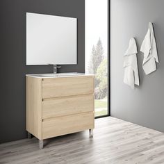 a bathroom vanity with two towels hanging on the wall and a large window in the background