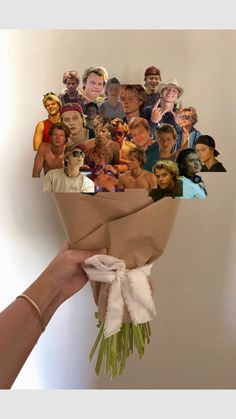 a hand holding a bunch of different faces on a brown paper wrapped in some sort of wrapping