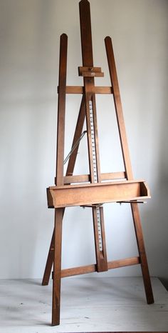 a wooden easel sitting on top of a white floor