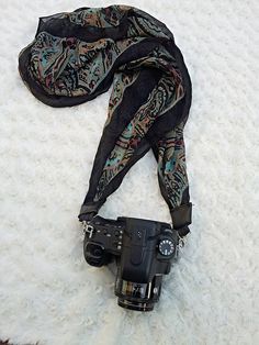 a camera and scarf laying on the floor