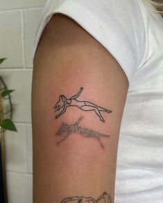 a woman with a tattoo on her arm that has an image of a man diving