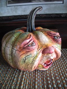 a ceramic pumpkin with an evil face on it