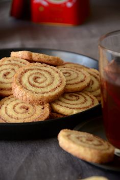 a plate full of cookies next to a glass of tea