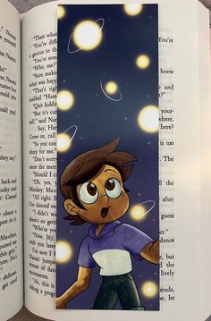 an open book with a drawing of a boy on the page and lights in the background