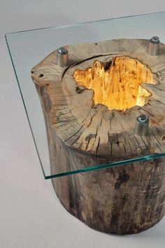 a glass table with a wooden base and metal fittings on the top that has a hole in it