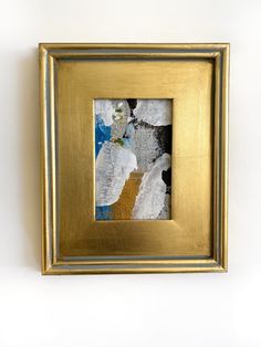 a gold frame with an abstract painting on it