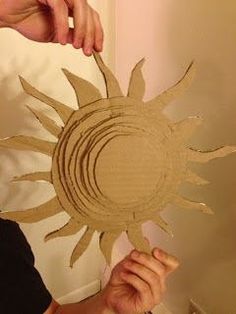 a person holding up a cardboard sun