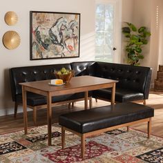 a living room with black leather couches and a wooden table in front of a painting