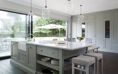 a large kitchen with an island in the middle and lots of stools around it