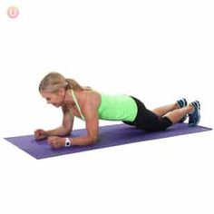 a woman is doing push ups on a purple mat