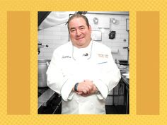 a man in a chef's outfit standing in a kitchen with his arms crossed