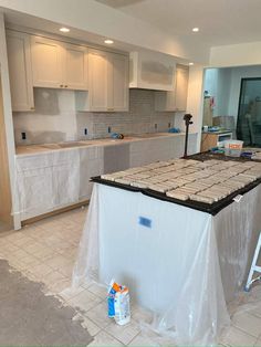 a kitchen being remodeled with white cabinets and tile on the counter top, in preparation for remodeling