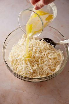 someone is pouring grated cheese into a bowl