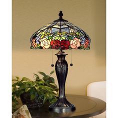 a table lamp sitting on top of a wooden table next to a potted plant