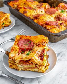 a white plate topped with lasagna next to a casserole dish filled with meat