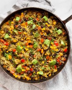 a skillet filled with mexican rice and vegetables