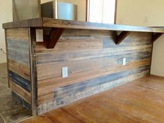 a kitchen counter made out of wooden planks in a room with tile flooring