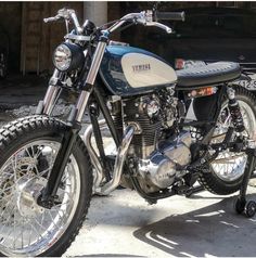 a black and white yamaha motorcycle parked in front of a building with other motorcycles behind it