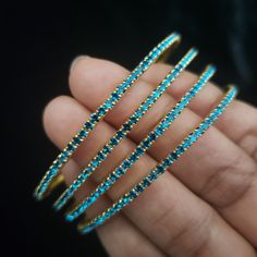 "* Handcrafted Gold Plated 4 Bangle Set. Sold as a set. * Bangles with high quality blue stones. * High Quality 22K Gold Plated. Bangles Sizes : 2.4 ( 2.20\" diameter of the inner circle) ; 2.6 ( 2.40\" diameter of the inner circle); 2.8 (2.50\" diameter of the inner circle) The gorgeous gold-plated bangles set best exemplifies the careful craftsmanship done on it -- specially picked for you by Nemali Jewelry. It has a special tone of elegance attached to it. The intricate handmade design of the Festive Blue Round Bangle, Traditional Blue Bangle For Party, Blue Hand Set Bangle For Wedding, Blue Hand-set Bangle For Wedding, Adjustable Round Blue Bangle, Adjustable Blue Stackable Bangle, Blue Festive Bracelet Jewelry, Festive Blue Bracelet Jewelry, Festive Blue Bracelet