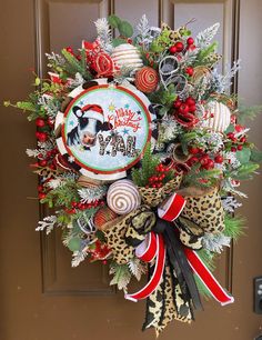 a christmas wreath on the front door with an image of a cow and candy canes