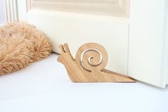 a small wooden snail sitting next to a door