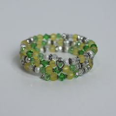 "Limeade Dazzle"- This is a fun piece that stands out in a crowd. Bright, vibrant colors of yellow and green. The yellow represents happiness, the green represents growth. This bracelet is sure to bring happiness with its cheerful look. At Le Joli Minou all of our bracelets are one of a kind designs. And each bracelet comes packaged in a hand crocheted, cat shaped pouch for safe keeping! Your bracelet is ready to ship today! Adjustable Green Charm Bracelet For Party, Green Bangle Jewelry For Friendship, Green Bangle Charm Bracelet For Jewelry Making, Hand Wrapped Green Bracelet Jewelry, Yellow Friendship Bangle Jewelry, Green Hand-wrapped Bracelet Jewelry, Yellow Stackable Bracelets As Gift, Hand Wrapped Yellow Bracelet Jewelry, Green Stretch Bangle Bracelet For Friendship