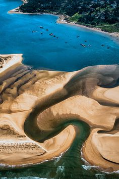 an aerial view of sand dunes and water