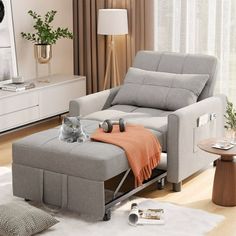 a cat sitting on top of a gray couch in a living room