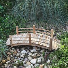 a wooden bridge surrounded by rocks and plants