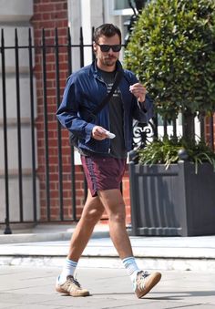 a man walking down the street in shorts