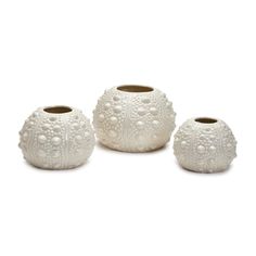 three white vases sitting next to each other