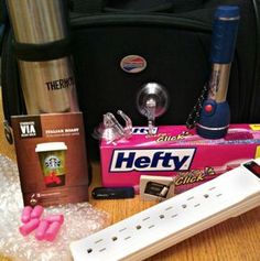 the contents of a travel bag sitting on top of a wooden table next to a cup