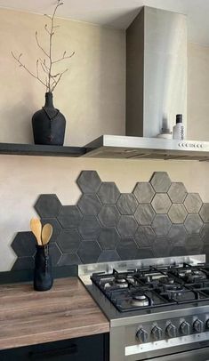 a stove top oven sitting inside of a kitchen next to a wall mounted range hood