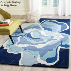 a blue and white rug with an abstract flower design on the floor in a living room