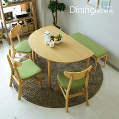 a dining table with green chairs and a bowl of fruit on the table next to it