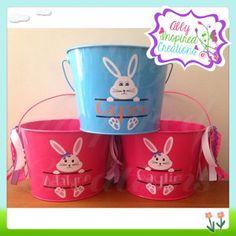 three buckets with bunny faces painted on them, one is blue and the other has pink