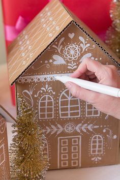 These DIY Gingerbread house gift boxes will display presents beautifully. The gift boxes are created with cardboard and Painters makers for easy crafting. Cardboard Gingerbread House, House Gift Box, Hantverk Diy, Boxes Diy, Gingerbread Diy, Christmas Gingerbread House