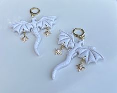 White sparkly glitter dragons made from clay, each dragon with two 18k gold plated north star charms  *also available in black sky glitter, please see other listings  My earrings are handmade with polymer clay, an extremely light weight and versatile material. Each individual piece is handcrafted with care and attention, no two are alike. There may be slight variations in colors or shape and potential imperfections.  Choose your hardware made from gold* or silver and choose between ball posts, l Dragon Clay, Fantasy Earrings, Polymer Clay Dragon, Celestial Earrings, Clay Dragon, Handmade Clay Jewelry, Dragon Earrings, Black Sky, Gold Dragon